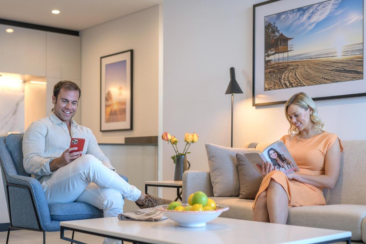 Meriton Suites Surfers Paradise Gold Coast Exterior photo A couple reading a magazine in their living room